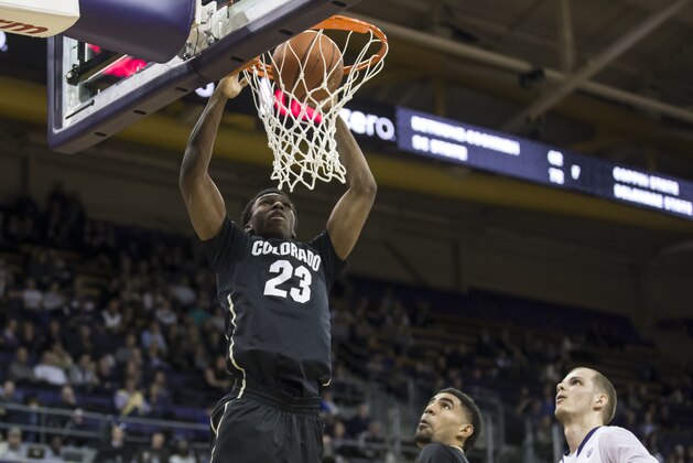 Colorado's Jaron Hopkins, left, scores as teammate Josh Scott, second from right, and Washington's Gilles Dierickx watch during the second half of an NCAA college basketball game Thursday, March 5, 2015, in Seattle. Colorado won 64-47. (AP Photo/Stephen Brashear)
