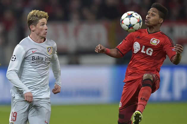 Atletico's Fernando Torres, left, watches as Leverkusen's Wendell controls the ball during the Champions League round of 16 first leg soccer match between Bayer 04 Leverkusen and Atletico de Madrid on Wednesday, Feb. 25, 2015 in Leverkusen, Germany. (AP Photo/Martin Meissner)