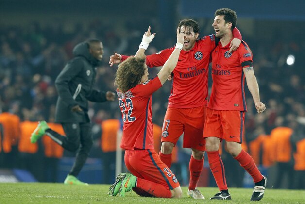 PSG's David Luiz, left, celebrates with teammates at the end of their Champions League round of 16 second leg soccer match between Chelsea and Paris Saint Germain at Stamford Bridge stadium in London, Wednesday, March, 11, 2015. Thiago Silva sent 10-man Paris Saint-Germain into the Champions League quarterfinals on away goals after a 2-2 draw at Chelsea in extra time of a fiery and ill-disciplined game on Wednesday. (AP Photo/Alastair Grant)