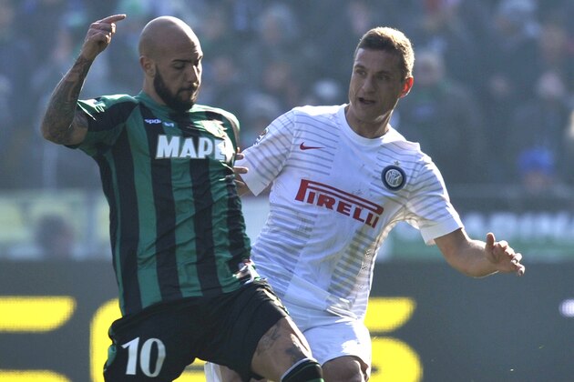 Sassuolo's Simone Zaza, left, vies for the ball with Inter Milan's Nemanja Vidic, during their Serie A soccer match at Reggio Emilia's Mapei stadium, Italy, Sunday, Feb. 1, 2015. (AP Photo/Marco Vasini)