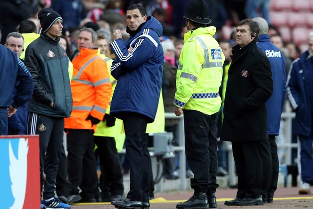 Sunderland's manager Gus Poyet, center, stands dejected aftter being defeated by Aston Villa at the end of their English Premier League soccer match between Sunderland and Aston Villa  at the Stadium of Light, Sunderland, England, Saturday, March, 14, 2015. (AP Photo/Scott Heppell)