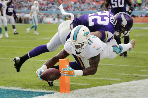 Miami Dolphins wide receiver Mike Wallace (11) scores a touchdown as Minnesota Vikings free safety Harrison Smith (22) is late with the tackle during the second half of an NFL football game, Sunday, Dec. 21, 2014, in Miami Gardens, Fla. (AP Photo/Lynne Sladky)