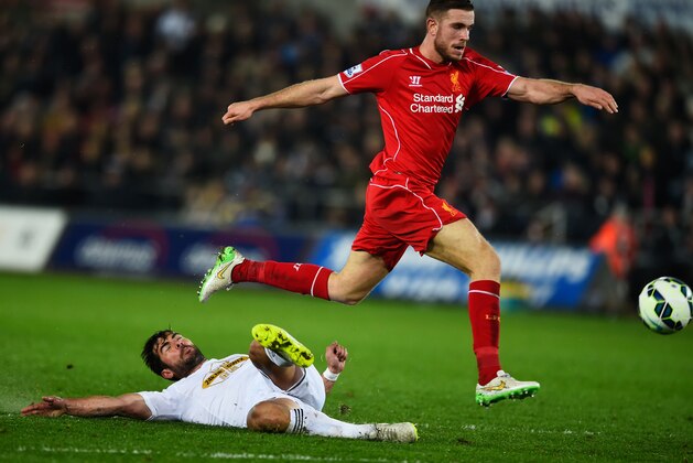 SWANSEA, WALES - MARCH 16:  Jordan Henderson of Liverpool is challenged by Jordi Amat of Swansea City leading to Liverpool's opening goal during the Barclays Premier League match between Swansea City and Liverpool at Liberty Stadium on March 16, 2015 in Swansea, Wales.  (Photo by Mike Hewitt/Getty Images)