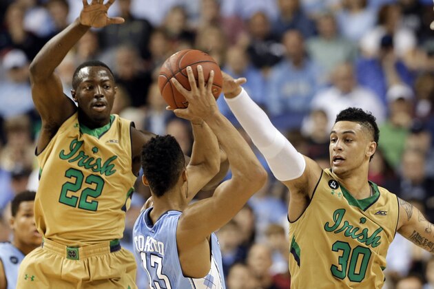 North Carolina's J.P. Tokoto (13) tries to pass against Notre Dame's Zach Auguste (30) and Jerian Grant (22) during the first half of an NCAA college basketball game in the championship of the Atlantic Coast Conference tournament Saturday, March 14, 2015, in Greensboro, N.C. (AP Photo/Gerry Broome)