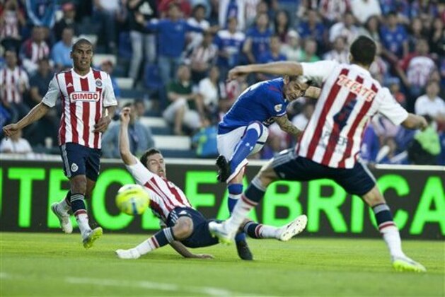 In this Saturday, Feb.  21, 2015 photo, Cruz Azul's Rogelio Chavez, second right, shoots, but fails to score under pressure from Chivas' Israel Castro, bottom cemter, and Jair Pereira, right, during a Mexican soccer league match in Mexico City. (AP Photo/Christian Palma)