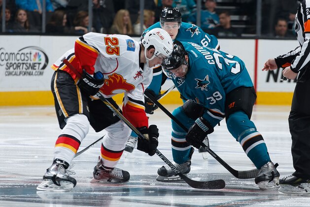 SAN JOSE, CA - JANUARY 17: Logan Couture #39 of the San Jose Sharks gets faces-off against Sean Monahan #23 of the Calgary Flames during an NHL game on January 17, 2015 at SAP Center in San Jose, California. (Photo by Don Smith/NHLI via Getty Images)