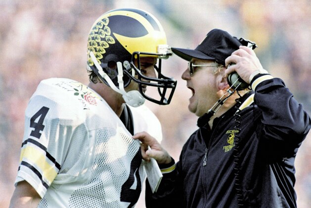 FILE - In this Jan. 2, 1987, file photo, Michigan head coach Bo Schembechler yells at quarterback Jim Harbaugh as the Wolverines fell victim to Arizona State 22-15 in the Rose Bowl NCAA college football game in Pasadena, Calif. The former Wolverines quarterback is returning to Ann Arbor, to coach his alma mater. The 51-year-old Harbaugh signed a seven-year deal to become the new coach at Michigan that will pay him $5 million per year. (AP Photo/Reed Saxon, File)