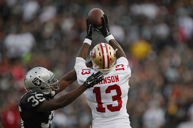 OAKLAND, CA - DECEMBER 7:  Wide receiver Stevie Johnson #13 of the San Francisco 49ers tries unsuccessfully to pull down a pass against cornerback Chimdi Chekwa #35 of the Oakland Raiders in the second quarter on December 7, 2014 at O.co Coliseum in Oakland, California.  The Raiders won 24-13.  (Photo by Brian Bahr/Getty Images)