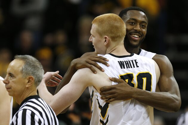 Iowa center Gabriel Olaseni and Iowa forward Aaron White hug as they get ready to exit the game during the second half of an NCAA college basketball game against Northwestern, Saturday, March 7, 2015, in Iowa City, Iowa. Iowa won 69-52. (AP Photo/Justin Hayworth)