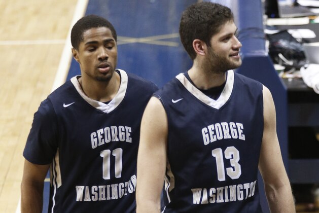 George Washington's Kethan Savage (11) and Patricio Garino (13) look to fans in the stands as they leave the court after defeating Pittsburgh in the first round of the NIT Tournament, NCAA college basketball game on Tuesday, March 17, 2015, in Pittsburgh. George Washington won 60-54 to advance to the second round of the tournament. (AP Photo/Keith Srakocic)
