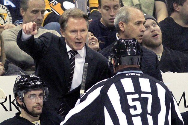 Jan 27, 2015; Pittsburgh, PA, USA; Pittsburgh Penguins head coach Mike Johnston (left) gestures as he talks with linesman Jay Sharrers (57) against the Winnipeg Jets during the second period at the CONSOL Energy Center. The Penguins won 5-3. Mandatory Credit: Charles LeClaire-USA TODAY Sports
