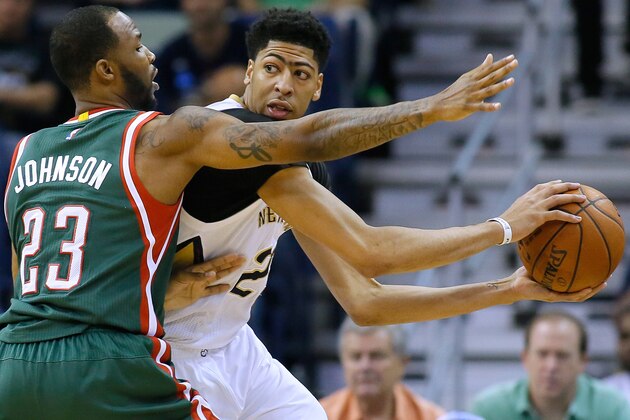 New Orleans Pelicans forward Anthony Davis, center, drives against Milwaukee Bucks forward Chris Johnson (23) during the first half of an NBA basketball game, Tuesday, March. 17, 2015, in New Orleans. (AP Photo/Jonathan Bachman)