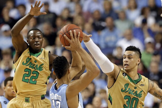 North Carolina's J.P. Tokoto (13) tries to pass against Notre Dame's Zach Auguste (30) and Jerian Grant (22) during the first half of an NCAA college basketball game in the championship of the Atlantic Coast Conference tournament Saturday, March 14, 2015, in Greensboro, N.C. (AP Photo/Gerry Broome)