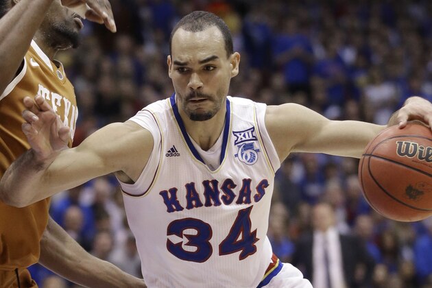 Kansas forward Perry Ellis (34) drives on Texas center Prince Ibeh, left, during the first half of an NCAA college basketball game at Allen Fieldhouse in Lawrence, Kan., Saturday, Feb. 28, 2015. (AP Photo/Orlin Wagner)