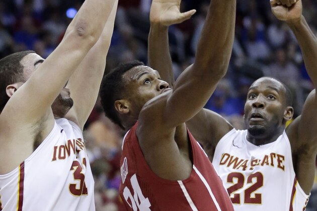 Oklahoma guard Buddy Hield (24) puts up a shot while covered by Iowa State forwards Georges Niang (31) and Dustin Hogue (22) during the first half of an NCAA college basketball game in the semifinals of the Big 12 Conference tournament in Kansas City, Mo., Friday, March 13, 2015. (AP Photo/Orlin Wagner)