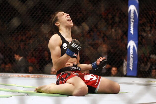 Mar 14, 2015; Dallas, TX, USA;  Joanna Jedrzejczyk (blue) celebrates defeating Carla Esparza (red) in the women's strawweight title bout during UFC 185 at American Airlines Center. Mandatory Credit: Tim Heitman-USA TODAY Sports