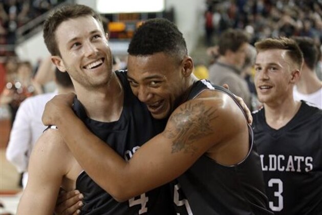 Davidson's Tyler Kalinoski (4) celebrates the team's 77-60 upset win over Dayton with teammate Jordan Barham (5) following an NCAA college basketball game in Davidson, N.C., Tuesday, Jan. 20, 2015. Davidson's Brian Sullivan is at right. (AP Photo/Bob Leverone)