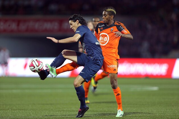 PSG's Edinson Cavani challenges for the ball with Lorient's defender Yoann Wachter, right, during their League One soccer match in Lorient, western France, Saturday, Nov 1, 2014. PSG won 2-1. (AP Photo/David Vincent)