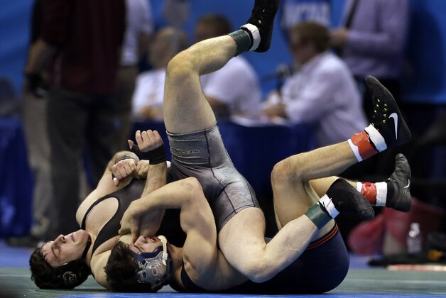 Army's Russell Parsons, left, and Illinois' Isaiah Martinez wrestle during their 157-pound first-round match Thursday, March 19, 2015, at the NCAA Division I Wrestling Championships in St. Louis. (AP Photo/Jeff Roberson)