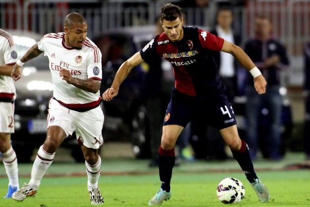 CAGLIARI, ITALY - OCTOBER 29: Nigel de Jong (L) of AC Milan and Lorenzo Crisetig of Cagliari in action during the Serie A match between Cagliari Calcio and AC Milan at Stadio Sant'Elia on October 29, 2014 in Cagliari, Italy.  (Photo by Enrico Locci/Getty Images)