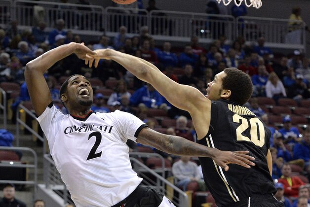 Cincinnati's Octavius Ellis, left, has his shot blocked by Purdue's A.J. Hammons during the first half of an NCAA tournament second-round college basketball game in Louisville, Ky., Thursday, March 19, 2015. (AP Photo/Timothy D. Easley)