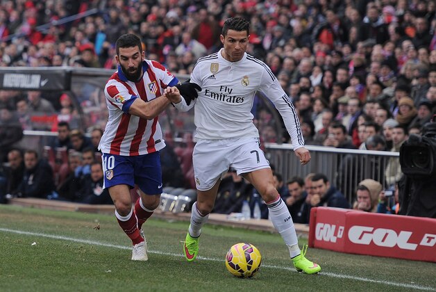MADRID, SPAIN - FEBRUARY 07:  Cristiano Ronaldo of Real Madridis tackled by Arda Turan of Club Atletico de Madrid during the La Liga match between Club Atletico de Madrid and Real Madrid at Vicente Calderon Stadium on February 7, 2015 in Madrid, Spain.  (Photo by Denis Doyle/Getty Images)
