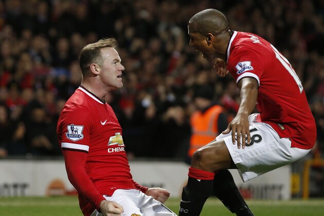 Manchester United’s Wayne Rooney, left celebrates after scoring with teammate Manchester United’s Ashley Young after he scored the opening goal of the game during the English FA Cup quarterfinal soccer match between Manchester United and Arsenal at Old Trafford Stadium, Manchester, England, Monday March 9, 2015. (AP Photo/Jon Super)