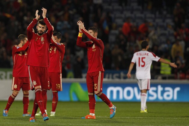 Spain's Gerard Pique, right waves at the end of the match against Belarus during the Euro 2016 qualifying match between Spain and Belarus at the Nuevo Colombino stadium, in Huelva, Spain, Saturday Nov. 15, 2014. Spain won 3-0. (AP Photo/Miguel Angel Morenatti)