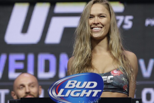 FILE - In this July 4, 2014, file photo, Ronda Rousey stands on the scale during a weigh-in for the UFC 175 mixed martial arts event at the Mandalay Bay in Las Vegas. Rousey has dominated every challenger in her two-year reign as the UFC's only women's bantamweight champion. Cat Zingano still believes she has a legitimate shot at Rousey's belt in UFC 184 on Saturday, Feb. 28, 2015, in Los Angeles. (AP Photo/John Locher, File)