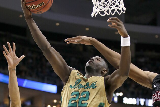 Notre Dame's Jerian Grant (22) shoots around Northeastern's Reggie Spencer, right, during the first half of a second round game in the NCAA college basketball tournament, Thursday, March 19, 2015, in Pittsburgh. (AP Photo/Gene J. Puskar)