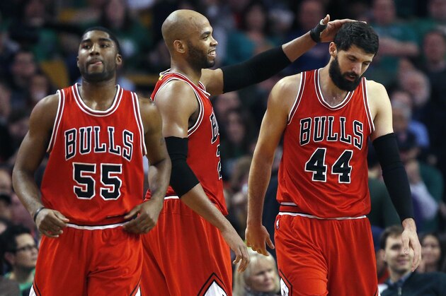 Chicago Bulls' Taj Gibson, center, pats Nikola Mirotic (44) as E'Twaun Moore (55) heads up court during the seoncd quarter of an NBA basketball game against the Boston Celtics in Boston, Friday, Jan. 16, 2015. (AP Photo/Michael Dwyer)