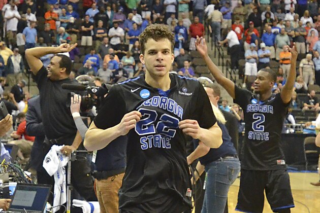 Georgia State's R.J. Hunter (22) comes off the court after making a game winning shot against Baylor, as head coach Ron Hunter, back left, and Ryann Green (2) celebrate their 57-56 in the second round of the NCAA college basketball tournament, Thursday, March 19, 2015, in Jacksonville, Fla. (AP Photo/Rick Wilson)