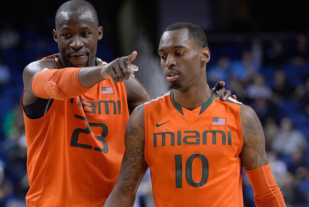 GREENSBORO, NC - MARCH 12:  Tonye Jekiri #23 talks with teammate Sheldon McClellan #10 of the Miami Hurricanes during their game against the Notre Dame Fighting Irish in the quarterfinals of the ACC Basketball Tournament at Greensboro Coliseum on March 12, 2015 in Greensboro, North Carolina.  (Photo by Grant Halverson/Getty Images)