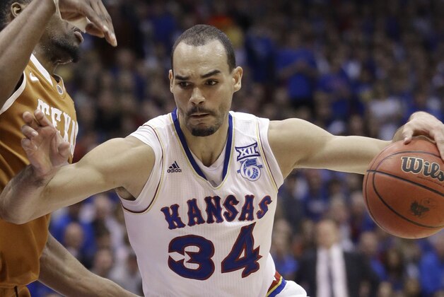 Kansas forward Perry Ellis (34) drives on Texas center Prince Ibeh, left, during the first half of an NCAA college basketball game at Allen Fieldhouse in Lawrence, Kan., Saturday, Feb. 28, 2015. (AP Photo/Orlin Wagner)