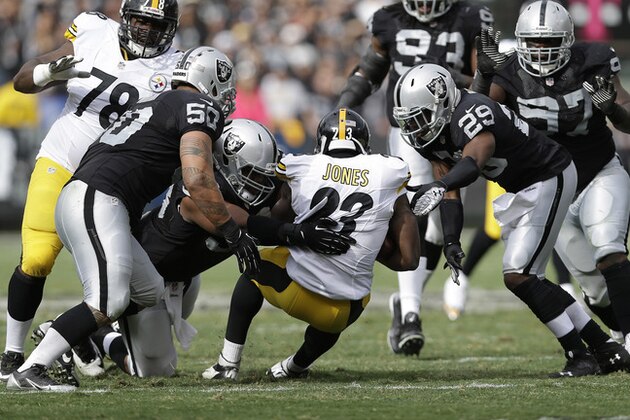 Oakland Raiders outside linebacker Kaluka Maiava (50), defensive tackle Vance Walker, second from bottom right, and cornerback Brandian Ross (29) tackle Pittsburgh Steelers running back Felix Jones (23) during the first half of an NFL football game in Oakland, Calif., Sunday, Oct. 27, 2013. (AP Photo/Marcio Jose Sanchez)