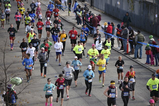 Runners race down 48th Avenue in Long Island City in the Queens borough of New York during the New York City Marathon on Sunday, Nov. 2, 2014, in New York. (AP Photo/Kathy Kmonicek)
