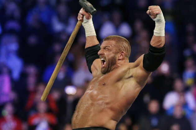 Wrestler Paul Michael Levesque, known as Triple H,holds up a hammer as he wrestles Brock Lesnar Sunday, April 7, 2013, in East Rutherford, N.J., during Wrestlemania. (AP Photo/Mel Evans)