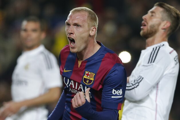 Barcelona's Jeremy Mathieu clenches his fist after scoring his side's first goal as Real Madrid's Sergio Ramos, right, fails to stop him during a Spanish La Liga soccer match between FC Barcelona and Real Madrid at Camp Nou stadium, in Barcelona, Spain, Sunday, March 22, 2015. (AP Photo/Emilio Morenatti)
