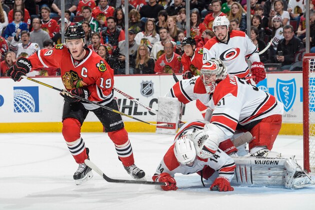 CHICAGO, IL - MARCH 21:  Nathan Gerbe #14 of the Carolina Hurricanes falls into teammate goalie Anton Khudobin #31 as Jonathan Toews #19 of the Chicago Blackhawks skates by during the NHL game on March 21, 2014 at the United Center in Chicago, Illinois.  (Photo by Bill Smith/NHLI via Getty Images)