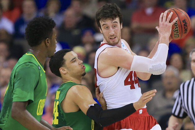 Wisconsin's Frank Kaminsky, right, is guarded by Oregon's Jordan Bell, left, and Dillon Brooks, center, during the first half of an NCAA tournament college basketball game in the Round of 32 in Omaha, Neb., Sunday, March 22, 2015. (AP Photo/Nati Harnik)