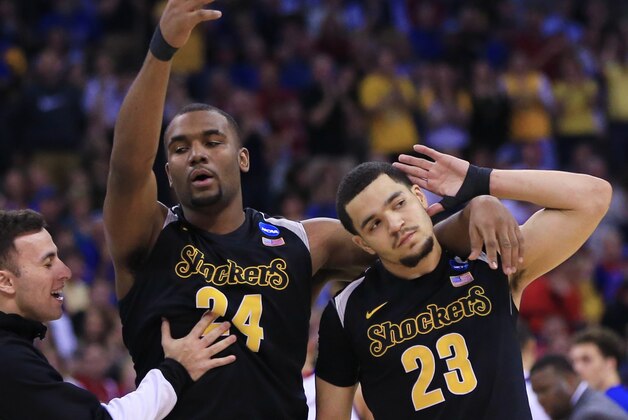 Wichita State's Fred VanVleet (23) and Wichita State's Shaquille Morris (24) gesture for crowd support during the second half of an NCAA tournament college basketball game against Kansas in the Round of 32 in Omaha, Neb., Sunday, March 22, 2015. (AP Photo/Nati Harnik)