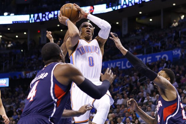 Oklahoma City Thunder guard Russell Westbrook (0) drives to the basket between two Atlanta Hawks defenders during the first half of a NBA basketball game in Oklahoma City, Friday, March 20, 2015. (AP Photo/Alonzo Adams)