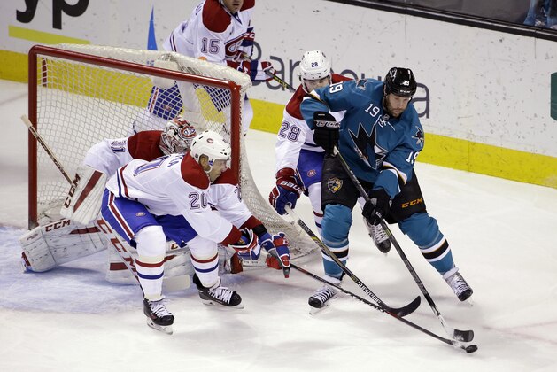 San Jose Sharks' Joe Thornton, right, tries to skate around Montreal Canadiens' Manny Malhotra (20) and Nathan Beaulieu (28)  during the first period of an NHL hockey game Monday, March 2, 2015, in San Jose, Calif. (AP Photo/Marcio Jose Sanchez)