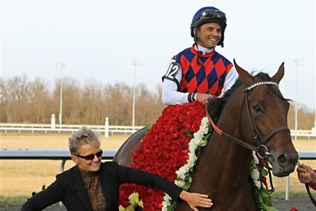Jose Lezcano , top right, celebrates aboard Spiral Stakes horse race winner Dubai Sky as assistant trainer Penny Gardiner, left, guides the colt to the Winner's Circle at Turfway Park race track in Florence, Ky., Saturday, March 21, 2015. (AP Photo/Garry Jones)