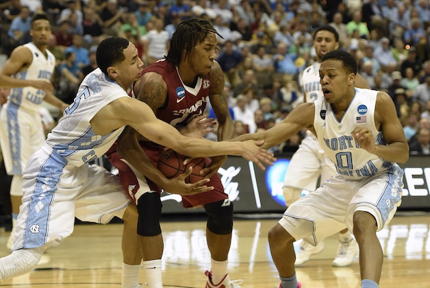 Mar 21, 2015; Jacksonville, FL, USA; North Carolina Tar Heels guard Marcus Paige (5) pressures Arkansas Razorbacks guard Michael Qualls (24) as North Carolina Tar Heels guard Nate Britt (0) helps out  in the second half of a game in the third round of the 2015 NCAA Tournament at Jacksonville Veterans Memorial Arena. Mandatory Credit: John David Mercer-USA TODAY Sports