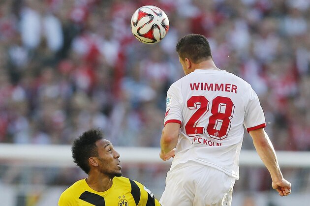 Dortmund's Pierre-Emerick Aubameyang from Gabun, left, and Cologne's Kevin Wimmer from Austria challenge for the ball during the German first division Bundesliga soccer match between 1.FC Cologne and BvB Borussia Dortmund in Cologne, Germany, Saturday, Oct. 18, 2014. (AP Photo/Frank Augstein)