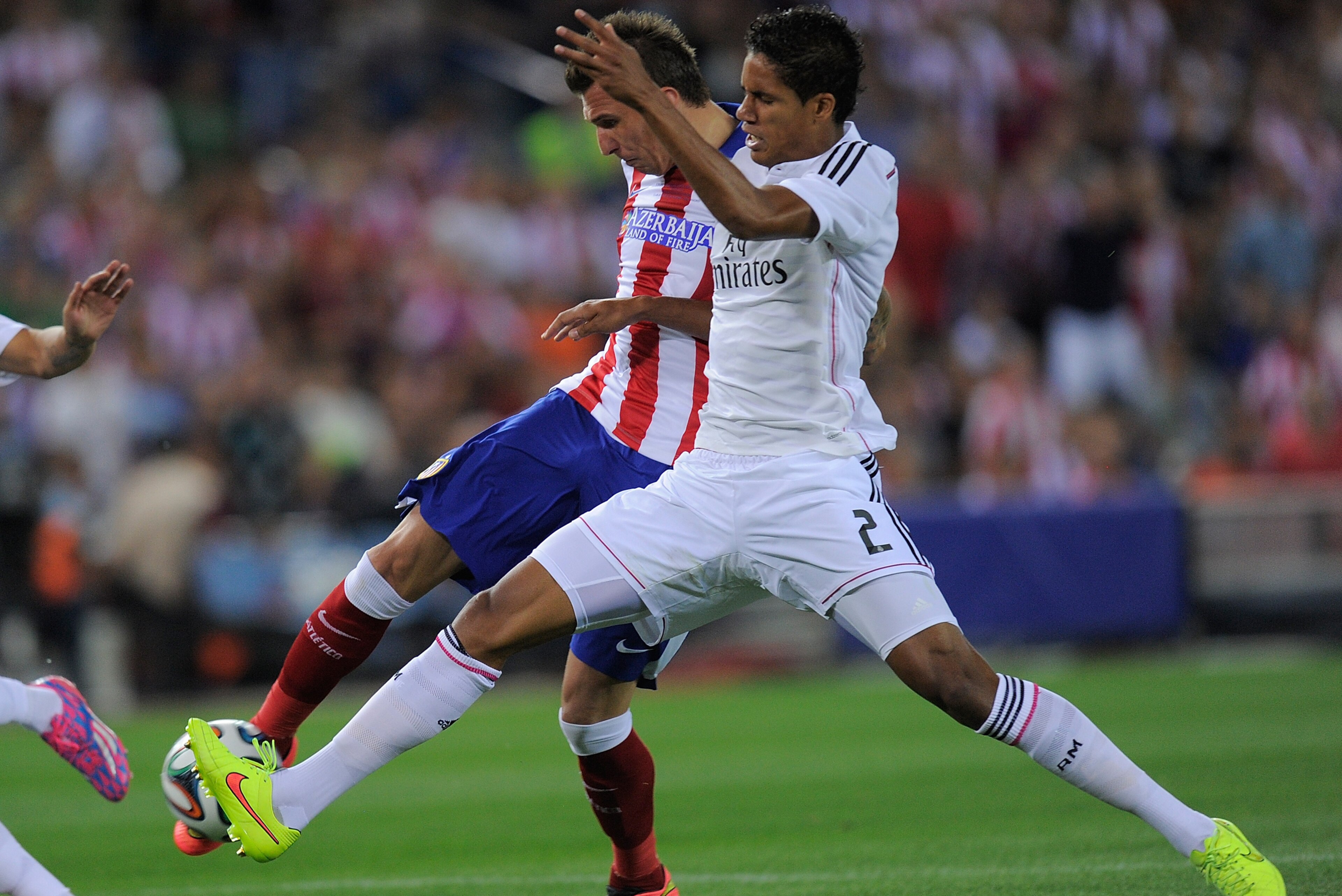 MADRID, SPAIN - AUGUST 22:  Mario Mandzukic of Club Atletico de Madrid beats Raphael Varane of Real Madrid to score his team's opening goal during the Supercopa, second leg match between Club Atletico de Madrid and Real Madrid at Vicente Caldron stadium on August 22, 2014 in Madrid, Spain.  (Photo by Denis Doyle/Getty Images)