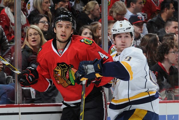 CHICAGO, IL - DECEMBER 29:  Niklas Hjalmarsson #4 of the Chicago Blackhawks and Filip Forsberg #9 of the Nashville Predators watch for the puck during the NHL game at the United Center on December 29, 2014 in Chicago, Illinois.  (Photo by Bill Smith/NHLI via Getty Images)