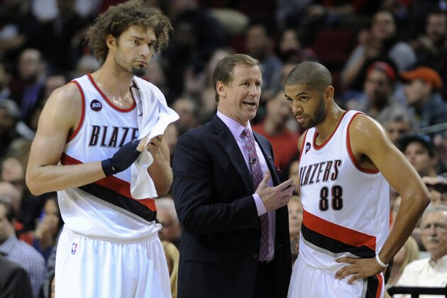 Portland Trail Blazers' head coach Terry Stotts, center, talks with Nicolas Batum (88) and Robin Lopez, right, during a timeout against the Dallas Mavericks during the second half of an NBA basketball game in Portland, Ore., Thursday, March 5, 2015. The Trail Blazers beat the Mavericks 94-75. (AP Photo/Greg Wahl-Stephens)