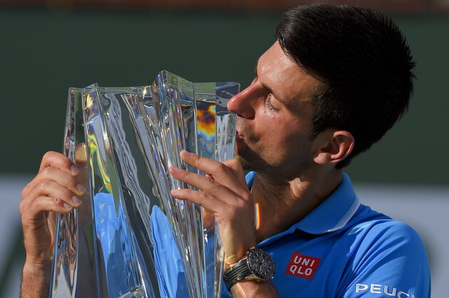 Novak Djokovic, of Serbia, kisses the trophy after his win over Roger Federer, of Switzerland, in the final match at the BNP Paribas Open tennis tournament, Sunday, March 22, 2015, in Indian Wells, Calif. (AP Photo/Mark J. Terrill)
